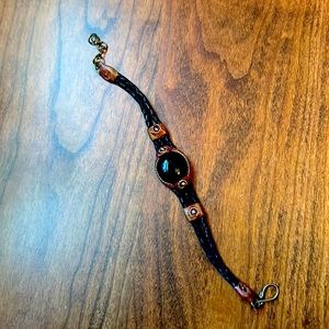 Leather bracelet with a black stone in the middle.